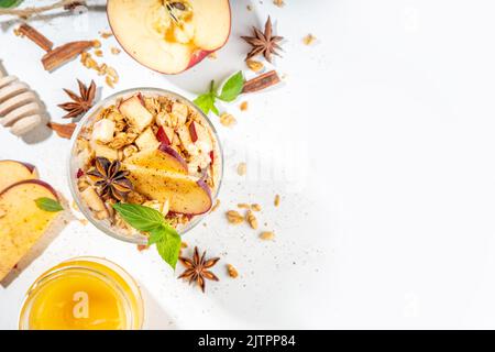 Gâteau au fromage Apple Pie Granola, petit-déjeuner en-cas, dessert avec granola d'avoine, yaourt au fromage à la crème, miel, tranches de pomme et épices à la cannelle sur blanc Banque D'Images