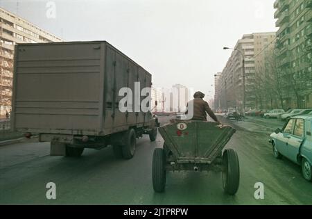 Bucarest, Roumanie, janvier 1990. Chariot rudimentaire tiré par des chevaux dans les rues sales de la capitale, quelques semaines après la révolution anticommuniste. Banque D'Images