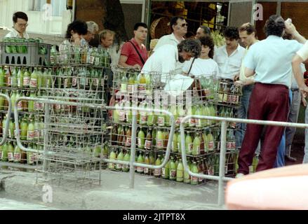 Bucarest, Roumanie, juin 1990. Quelques mois après la chute du communisme, un vendeur de boissons gazeuses a une bonne affaire. L'auto-entreprise était une nouveauté après 45 ans d'économie centralisée. Les boissons étaient vendues en bouteilles de verre réutilisables, comme c'était le cas à la période socialiste. Banque D'Images