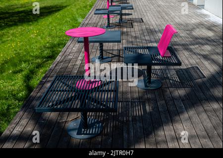 bancs et tables en métal colorés sur la terrasse par beau temps Banque D'Images