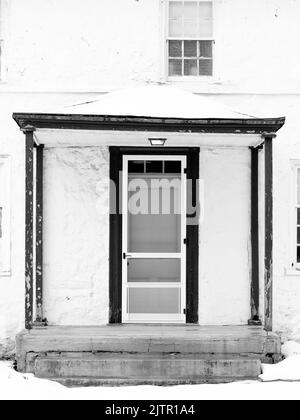 Photo verticale en niveaux de gris d'une porte d'une maison ancienne. Banque D'Images