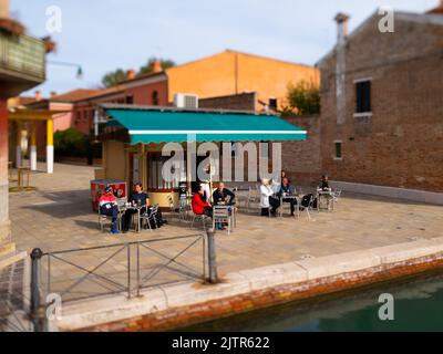 Venise, Italie - 25 octobre 2021: Petit café avec des gens à Murano un jour ensoleillé en automne, effet miniature Banque D'Images