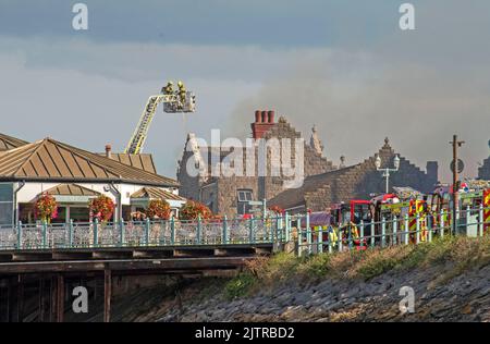 De la fumée s'illumine dans le ciel lorsqu'un incendie majeur a éclaté à la vieille discothèque Cendrillon de Mumbles Pier près de Swansea cet après-midi. Banque D'Images