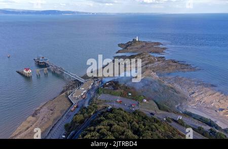 De la fumée s'illumine encore dans le ciel cet après-midi après qu'un incendie important a éclaté à la boîte de nuit de l'ancienne Cendrillon, le long de Mumbles Pier près de Swansea. Banque D'Images