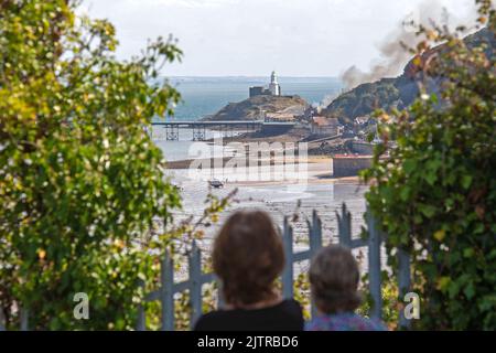 De la fumée s'illumine dans le ciel lorsqu'un incendie majeur a éclaté à la vieille discothèque Cendrillon de Mumbles Pier près de Swansea cet après-midi. Banque D'Images