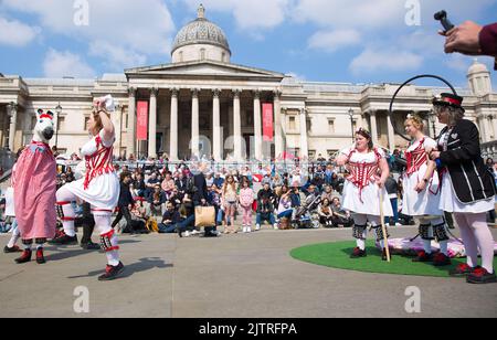 Les gens regardent les danseuses de Morris pendant qu'ils se rassemblent pour les célébrations de la fête de St George à Trafalgar Square, dans le centre de Londres. Banque D'Images