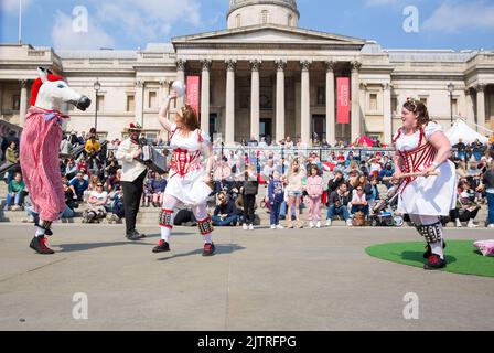 Les gens regardent les danseuses de Morris pendant qu'ils se rassemblent pour les célébrations de la fête de St George à Trafalgar Square, dans le centre de Londres. Banque D'Images