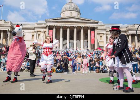 Les gens regardent les danseuses de Morris pendant qu'ils se rassemblent pour les célébrations de la fête de St George à Trafalgar Square, dans le centre de Londres. Banque D'Images