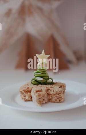 Concombre en forme d'arbre de Noël sur un bâton de cocktail poussé dans un sandwich avec une étoile de fromage. Banque D'Images