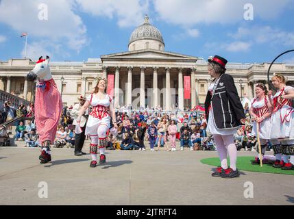 Les gens regardent les danseuses de Morris pendant qu'ils se rassemblent pour les célébrations de la fête de St George à Trafalgar Square, dans le centre de Londres. Banque D'Images