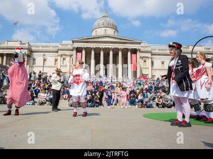 Les gens regardent les danseuses de Morris pendant qu'ils se rassemblent pour les célébrations de la fête de St George à Trafalgar Square, dans le centre de Londres. Banque D'Images