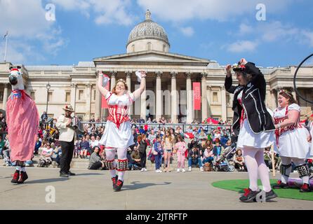 Les gens regardent les danseuses de Morris pendant qu'ils se rassemblent pour les célébrations de la fête de St George à Trafalgar Square, dans le centre de Londres. Banque D'Images