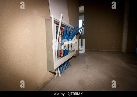 De nouvelles vannes à collecteur de système de distribution en laiton sont montées pour le plancher de chauffage central dans un bâtiment résidentiel en construction. Banque D'Images