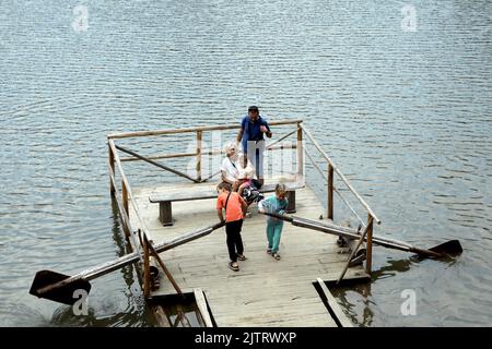 RÉGION DE ZAKARPATTIA, UKRAINE - 29 AOÛT 2022 - les adultes et les enfants séjournent sur le radeau du lac Synevyr, le plus grand lac de montagne d'Ukraine, comme le wat Banque D'Images