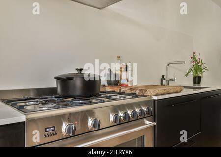 canapé avec coussins moelleux et cheminée électrique dans le salon lumineux près de la cuisine Banque D'Images