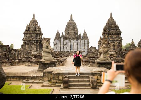 Un touriste pose pour une photo à l'ancien temple hindou de Prambanan à Jogjakarta (Yogyakarta), Java, Indonésie, Asie. Banque D'Images