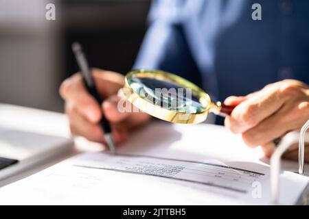 L'auditeur d'entreprise utilise la loupe pour l'audit de fraude fiscale Banque D'Images