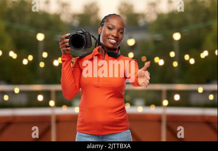 une femme heureuse avec un appareil photo qui lui donne la main pour la poignée de main Banque D'Images