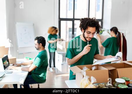 groupe de bénévoles emballant des aliments dans des boîtes de dons Banque D'Images