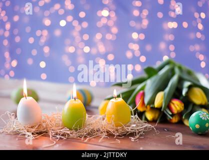 Bougies en forme d'œufs de pâques et fleurs tulipes Banque D'Images