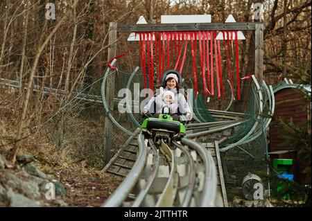 Mère avec sa fille, traîneau électrique sur les rails. Banque D'Images