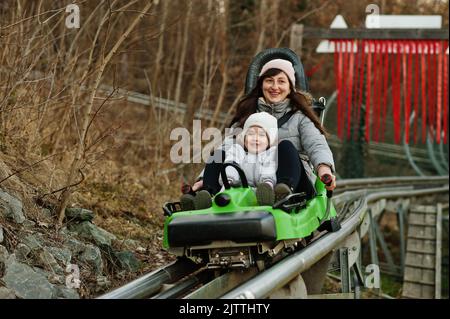 Mère avec sa fille, traîneau électrique sur les rails. Banque D'Images