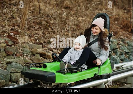 Mère avec sa fille, traîneau électrique sur les rails. Banque D'Images