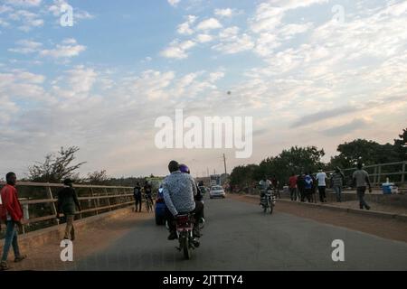 On voit un homme assis délicatement sur une moto dans le canton de Mtandile à Lilongwe. La moto est considérée comme un mode de transport moins cher et plus rapide par beaucoup de gens dans la ville. Malawi. Banque D'Images