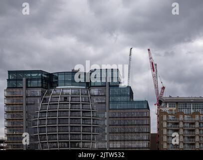 Londres, Angleterre, Royaume-Uni - 6 juillet 2022 : depuis la Tamise. Façade moderne en verre sphérique du bâtiment sur l'atterrissage se du pont Southwark sous un paysage sombre. Banque D'Images