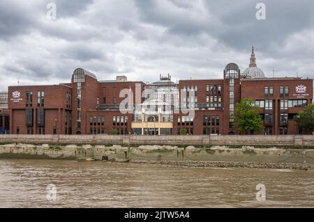 Londres, Angleterre, Royaume-Uni - 6 juillet 2022: De la rivière Thames. Brique rouge moderne ville de Londres bâtiment de l'école sous un paysage de nuages lourds. Dôme de Saint-Paul Cath Banque D'Images