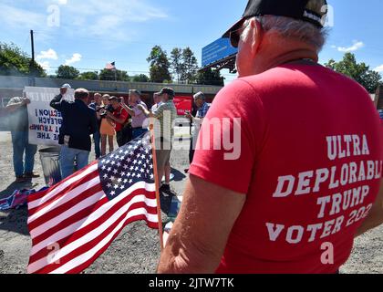 Un homme portant un t-shirt écrit sur « l'électeur 2024 de Trump, très déplorable, » regarde les films Gene Stilp brûlant un drapeau de Trump. Gene Stilp, un activiste politique connu pour avoir utilisé des accessoires, a organisé une protestation contre Donald Trump dans le canton de Wilkes-barre. Il est prévu que Trump se rallie ici samedi. Des manifestants sont également venus pour soutenir Trump en brandant les drapeaux américains et en portant des vêtements positifs pour Trump. Stilp a parlé pendant quelques instants puis a tiré un drapeau d'un sac avec TRUMP écrit sur lui et un swastike, le drapeau de bataille des Confédérés et un emblème de l'URSS. (Photo par Aimee Dilger/SOPA Images/Sipa USA) Banque D'Images