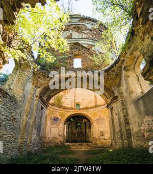 Tour endommagée de l'église abandonnée avec intérieur exposé à Lubycza Klolewska. Ruines de vieux temple entouré de plantes. Tir vertical . Photo de haute qualité Banque D'Images