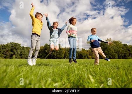 des enfants heureux sautant au parc Banque D'Images