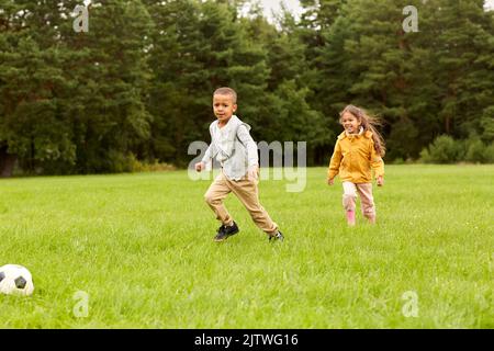 petits enfants avec le ballon jouant au football au parc Banque D'Images