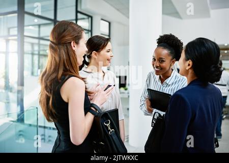 Ils donnent l'impression que les réunions stratégiques sont amusantes. Femme d'affaires debout et bavardant au bureau. Banque D'Images