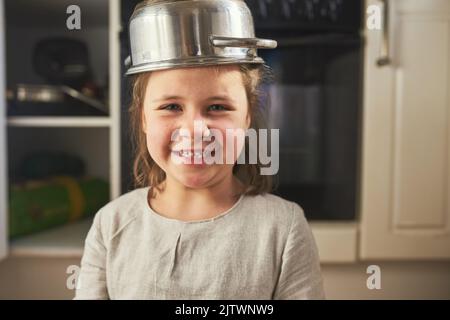 Vous aimez mon chapeau de fantaisie. Portrait court d'une petite fille portant un pot sur sa tête. Banque D'Images