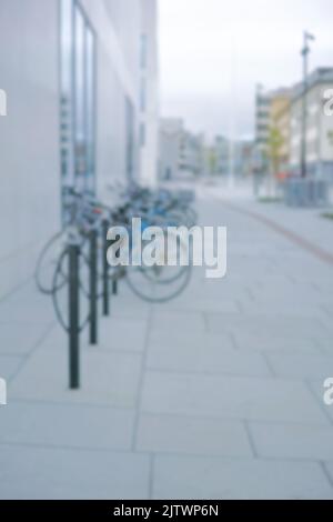 Prêt à rouler. Cliché flou d'une bicyclette à un porte-vélo dans une ville. Banque D'Images