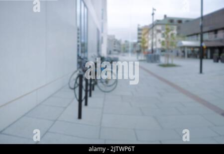 Prêt à rouler. Cliché flou d'une bicyclette à un porte-vélo dans une ville. Banque D'Images