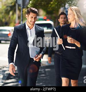 Pour réussir, il faut marcher et parler. Les collègues de l'entreprise discutent en marchant dans la rue. Banque D'Images