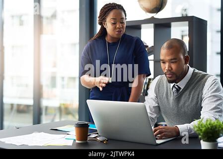 Pour quoi servent des collègues. Une jeune femme d'affaires qui aide un collègue de sexe masculin dans le bureau. Banque D'Images