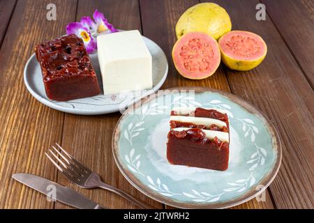 Tranches de fromage de goyave sucré et de caillé à côté d'un couteau de cuivre et d'une fourchette. Banque D'Images