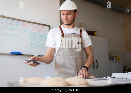 Le processus de fabrication de baguettes traditionnelles françaises. Former un blanc à partir de la pâte. Vue avant. Banque D'Images