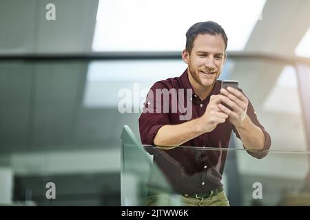 Un mauvais signal mobile est une chose du passé. Un homme d'affaires utilisant son téléphone portable dans un bureau moderne. Banque D'Images