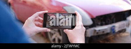 Agent d'assurance photographiant une voiture brisée sur un téléphone portable de près Banque D'Images