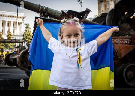 Kiev, Ukraine. 24th août 2022. Une petite fille, Sophia, avec un drapeau national ukrainien, danse devant un char russe détruit à Kiev. Dans le cadre du jour de l'indépendance de l'Ukraine, et près de 6 mois après l'invasion à grande échelle de l'Ukraine sur 24 février, la capitale du pays, Kiev, organise une exposition sur la rue principale de la rue Khreschaytk montrant plusieurs équipements militaires, chars et armes détruits par les forces armées de la Fédération de Russie (AFRF). Pendant le jour de l'indépendance de l'Ukraine et près de 6 mois après l'invasion à grande échelle de l'Ukraine sur 24 février, Kiev organise une exposition Banque D'Images