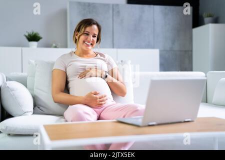 Femme enceinte utilisant un appel vidéo en ligne avec un médecin sur un ordinateur portable Banque D'Images