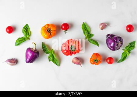 Composition des aliments. Mise en page créative faite de légumes biologiques et de basilic sur fond blanc. Vue de dessus. Pose à plat. Concept alimentaire végétalien Banque D'Images