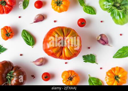 Composition des aliments. Tomates, basilic, ail et poivre isolés sur fond blanc. Pose à plat. Vue de dessus. Motif de légumes Banque D'Images