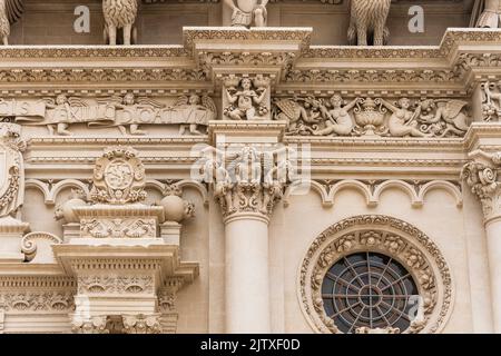 La façade richement décorée de la basilique de Santa Croce avec des statues, des colonnes et des fenêtres roses, à Lecce, Salento, région des Pouilles, dans le sud de l'Italie Banque D'Images