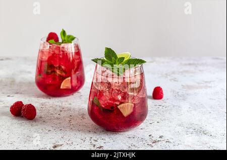 Limonade d'été fraîche à la framboise, au citron vert, à l'eau de soude et à la glace en verre. Banque D'Images